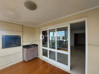 Sala de estar com piso de madeira e porta de vidro que dá para a varanda.