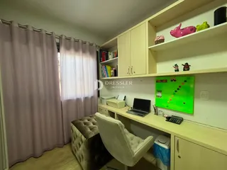 Quarto com cortinas e estantes de madeira em um imóvel.