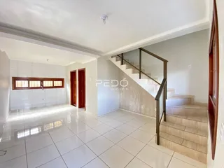 Corredor com piso de cerâmica branca e portas de madeira.