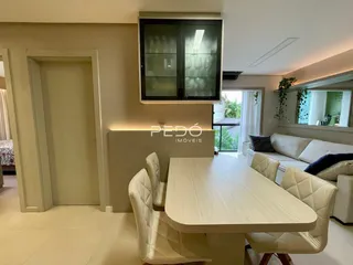 Área de jantar com mesa e cadeiras em um ambiente claro.