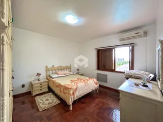Quarto com cama de madeira e janela no interior da residência.