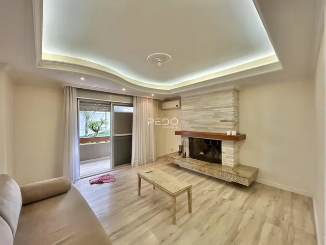 Sala de estar com piso de madeira clara e lareira em um imóvel no Brasil.