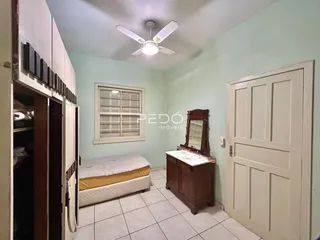 Quarto com paredes verde-claro e piso de cerâmica.