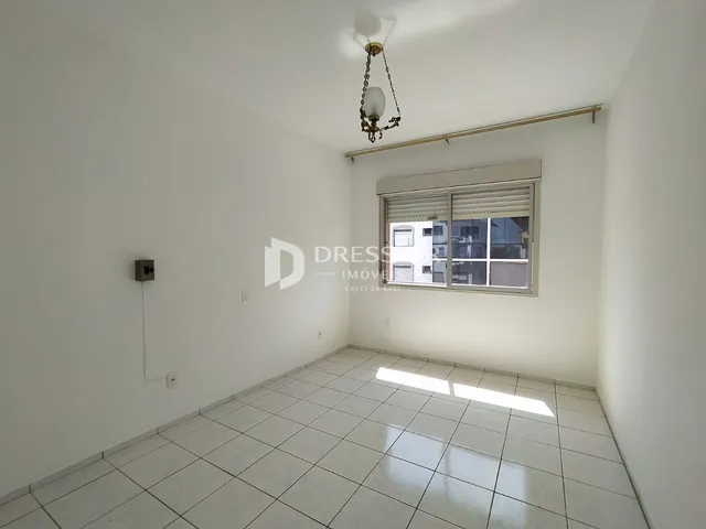Ambiente interno de uma sala com piso de cerâmica clara e paredes brancas.
