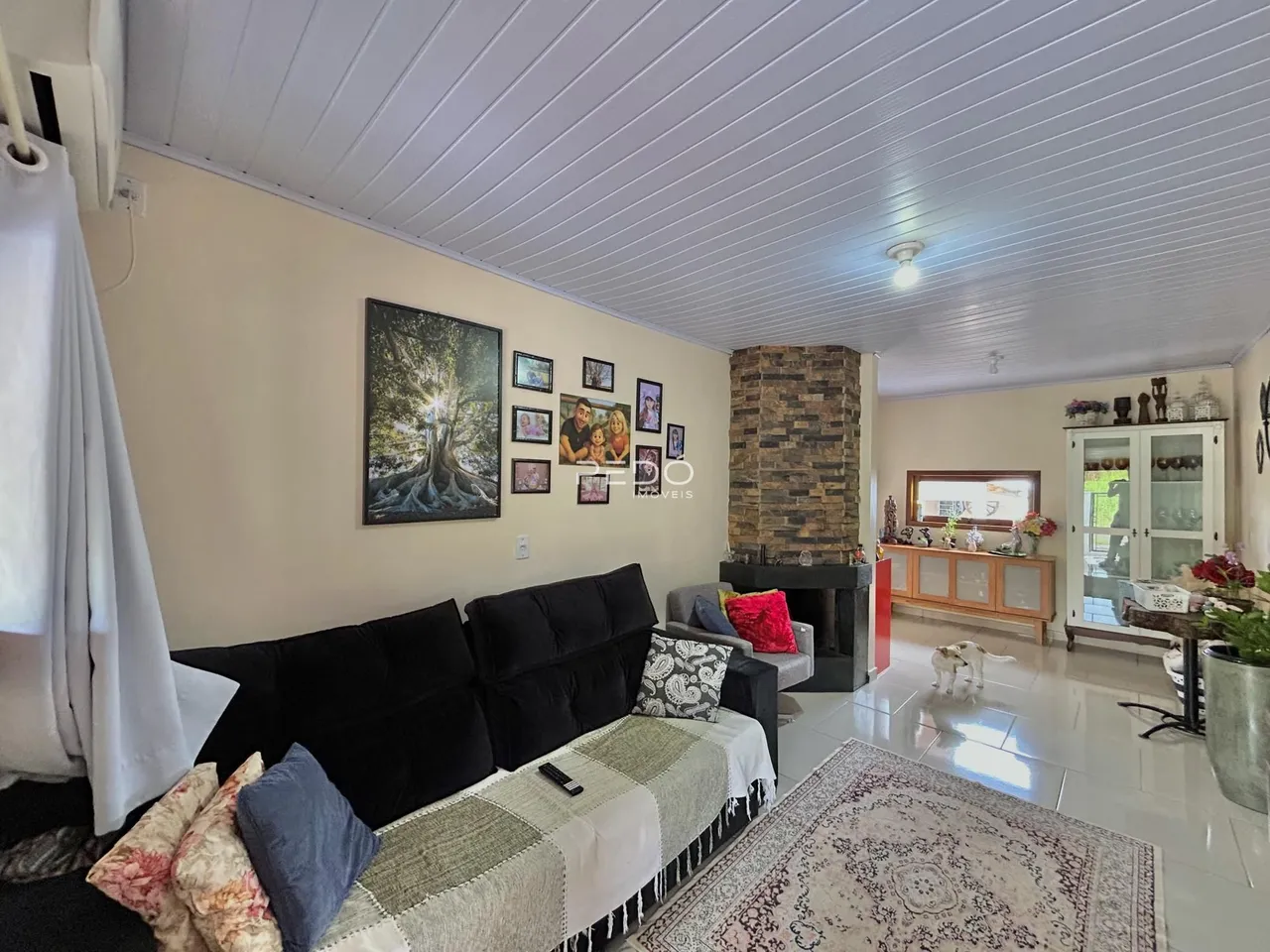 Sala de estar com sofá e lareira em um imóvel no Brasil.