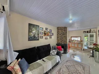 Sala de estar com sofá e lareira em um imóvel no Brasil.