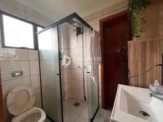 Foto de um banheiro com revestimento cerâmico e box de vidro.