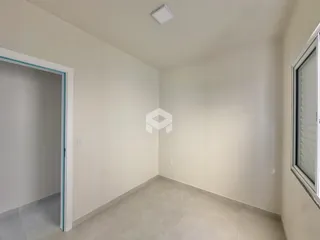 Interior de um ambiente com piso de cerâmica claro e paredes brancas.