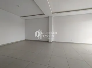Interior de uma sala com piso de cerâmica e paredes brancas.