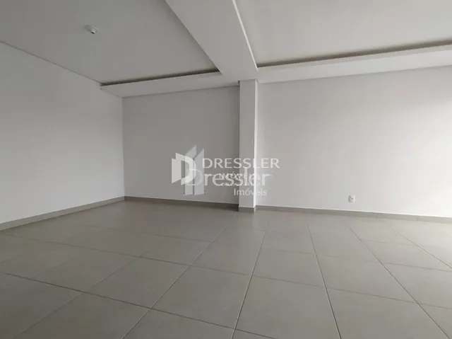 Interior de uma sala com piso de cerâmica e paredes brancas.