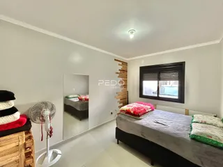 Quarto com cama e espelho em ambiente claro.