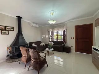 Sala de estar com lareira e móveis de madeira clara.