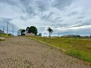 Vista de uma área pavimentada que leva a um campo gramado.