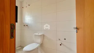 A foto mostra o interior de um banheiro com revestimento branco.