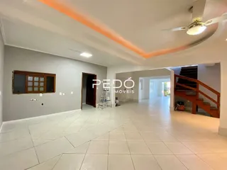 A foto mostra um corredor interno de uma residência com piso de cerâmica claro.