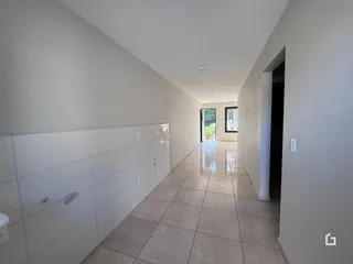 Corredor interno de uma residência com piso de cerâmica.