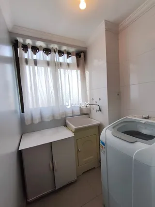 Interior de um cômodo com janela e móveis brancos.