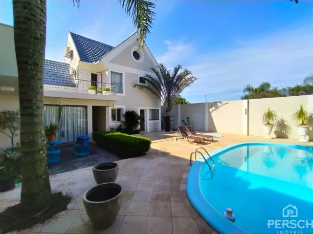 Fachada de uma residência com piscina e jardim em Lajeado.