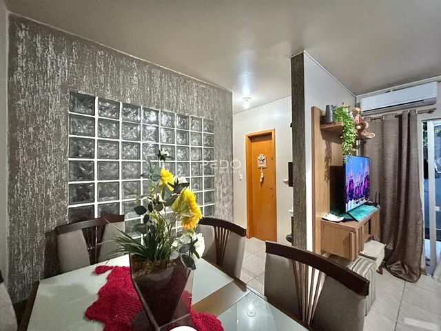 Ambiente interno com mesa de jantar e parede texturizada.