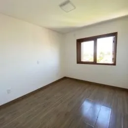 Foto de um cômodo interno com piso de madeira e janela.
