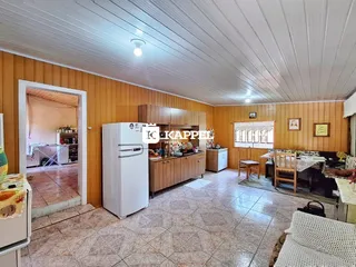 Cozinha com armários de madeira e piso de cerâmica.