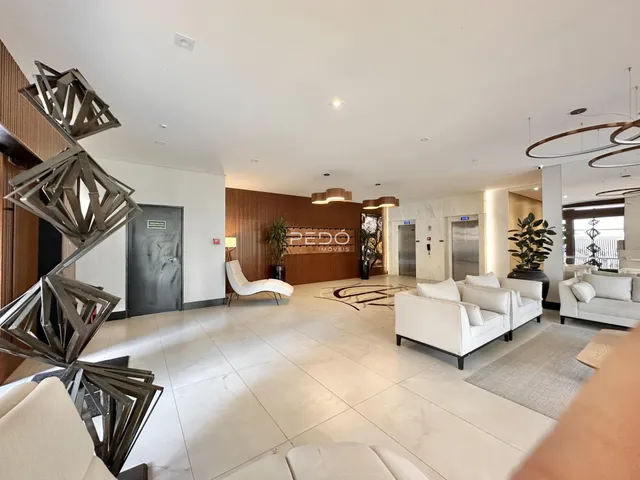 Sala de estar ampla com piso claro e decoração moderna.