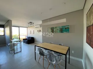 Sala de estar com grandes janelas e ambiente claro.