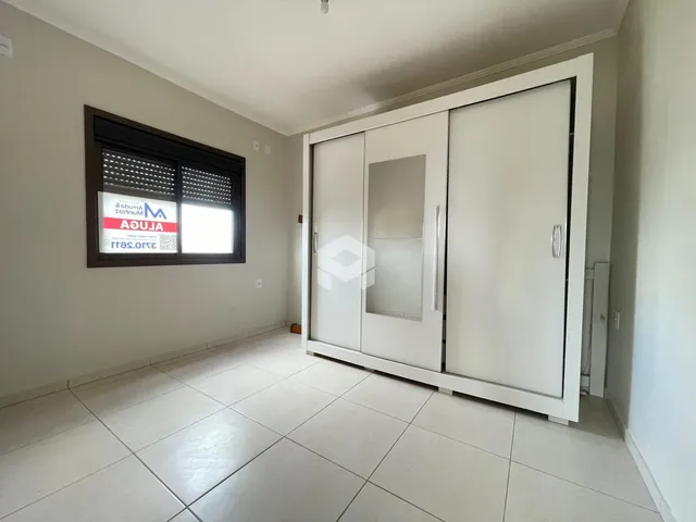 Interior de uma sala com piso de cerâmica e um armário embutido branco.