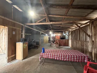 Interior de um espaço amplo com estrutura de madeira aparente.