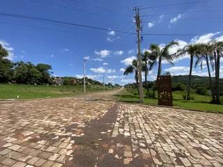 Vista externa de uma rua pavimentada com tijolos e área verde em Lajeado, Brasil.