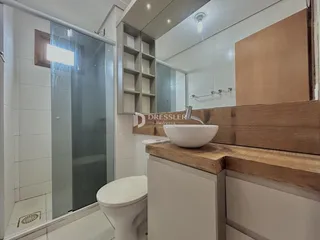 Foto de um banheiro com revestimento cerâmico e bancada de madeira.