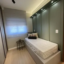Quarto com cama e janela com persianas no imóvel.