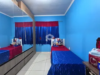 Quarto com paredes azuis e camas decoradas.