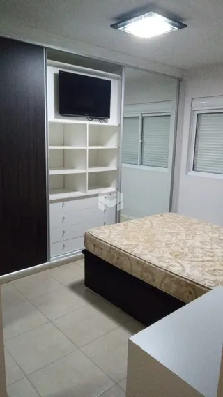 Quarto com cama e estante branca em um apartamento.