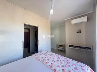 Quarto com cama e ar condicionado instalado na parede.