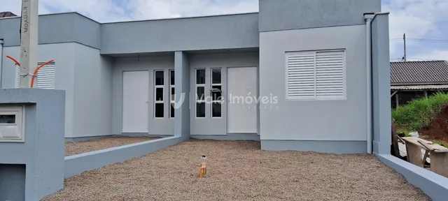 Fachada da casa em Lajeado, Brasil, com área externa coberta por cascalho.