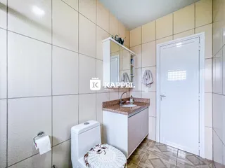 Foto de um banheiro com revestimento de azulejos claros e um lavatório.
