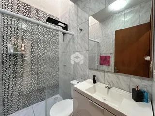 Foto de um banheiro com revestimento de azulejos e box de vidro.