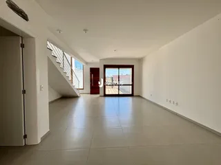 Corredor interno com piso de cerâmica e escada visível.