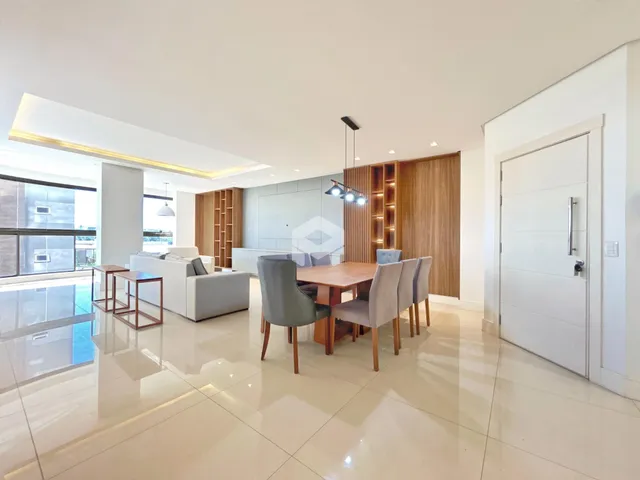 Sala de estar e jantar moderna com piso claro e grandes janelas.