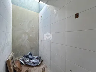 Parede interna com revestimento e materiais de construção expostos.