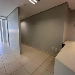 Foto de um corredor interno com piso de cerâmica clara.