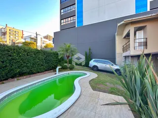 Vista externa de uma piscina e jardim em uma propriedade em Lajeado.