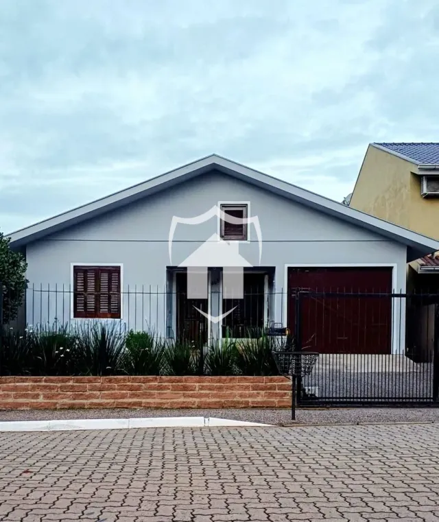 Fachada de uma casa em Lajeado, Brasil com cerca e portão de ferro.