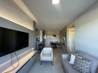 Sala de estar com sofá e televisão em um apartamento no Brasil.