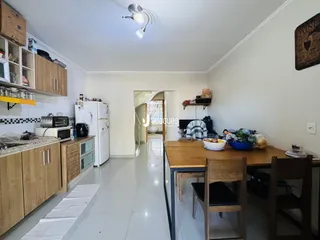 Ambiente interno de uma cozinha e sala de jantar em um imóvel no Brasil.