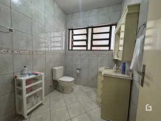 Foto de um banheiro com revestimento de azulejos e louças sanitárias.