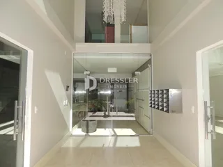 Hall de entrada com divisórias de vidro em um imóvel.