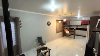 Ambiente interno de uma sala de estar com cozinha integrada.