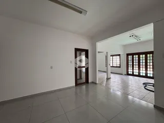 Corredor interno de uma residência com piso de cerâmica e paredes brancas.